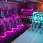 Kawaii 3D-printed figurines in synthwave neon, wrapped gifts on one side and a catalogue grid on the other